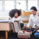 Mum packing suitcase with children.