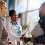 Adult couple speaking to a doctor.