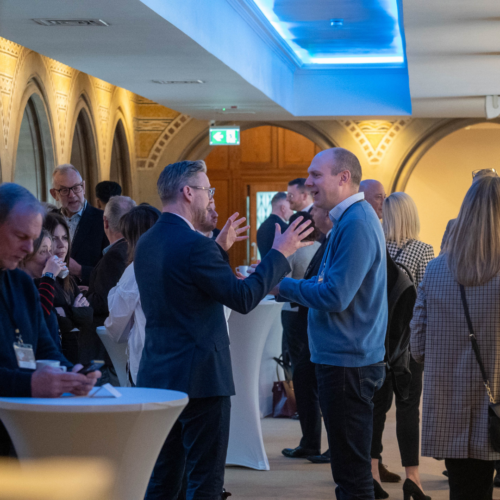 Conference attendees participating in discussion by a table.