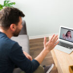 Man on a video call with his partner using a laptop at home