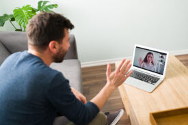 Man on a video call with his partner using a laptop at home